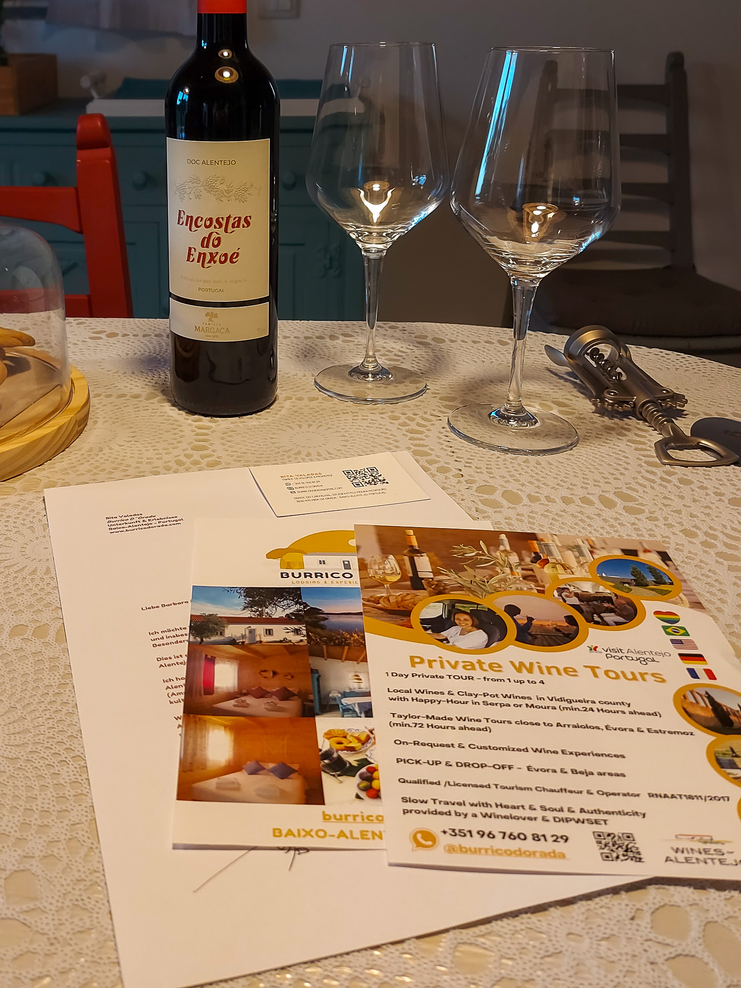 Willkommens-Tisch in der Burrico d'Orada mit Rotwein, Weingläsern und Regionsinfo
