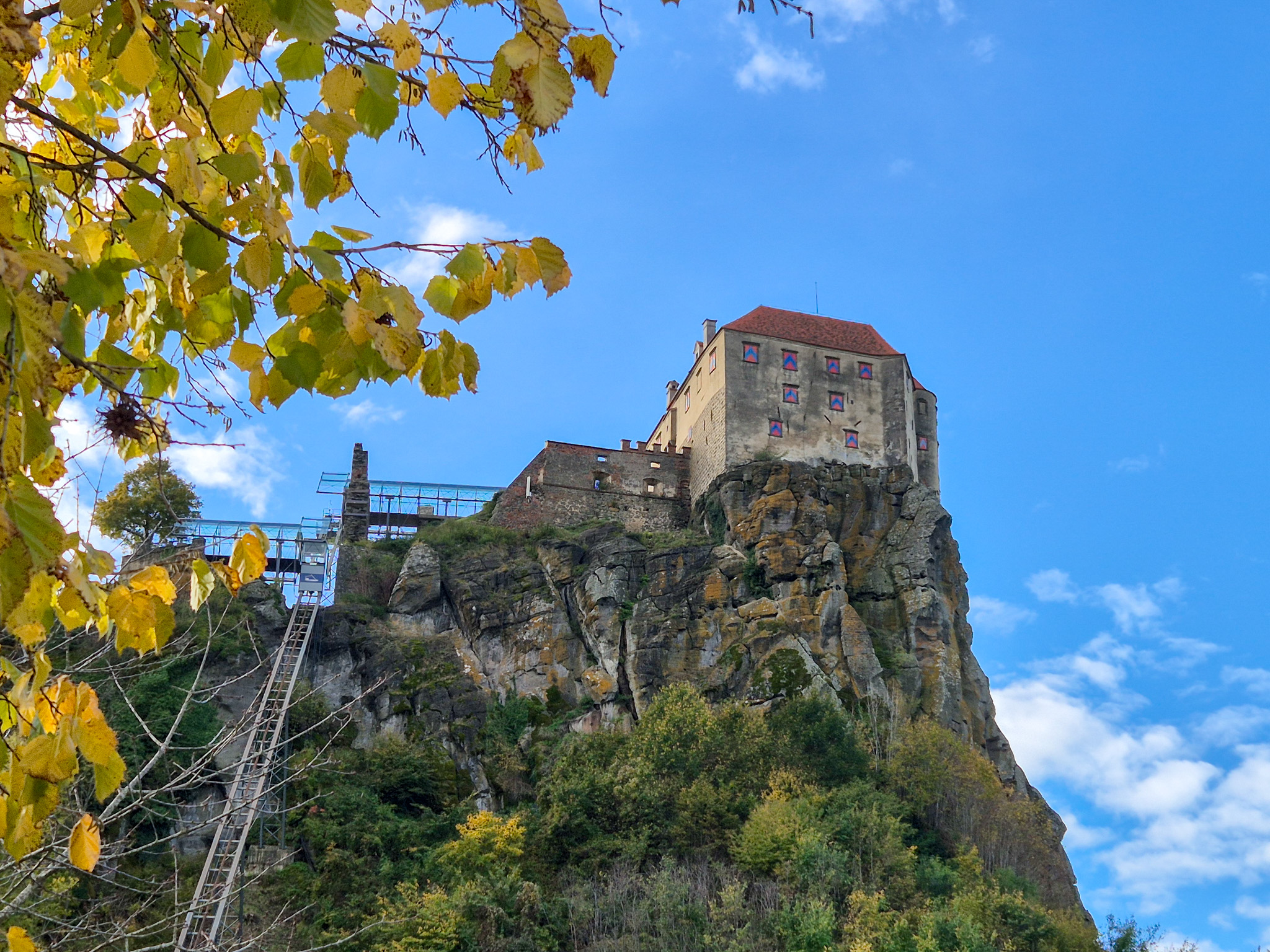 Riegersburg Eine schräg verlaufende Lifttrasse führt hinauf auf einen Felsen, auf dem eine Burg thront