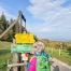 Eine Frau mit grünem Steiermark Rucksack betrachtet die gelben Wegweiser auf der Wanderroute